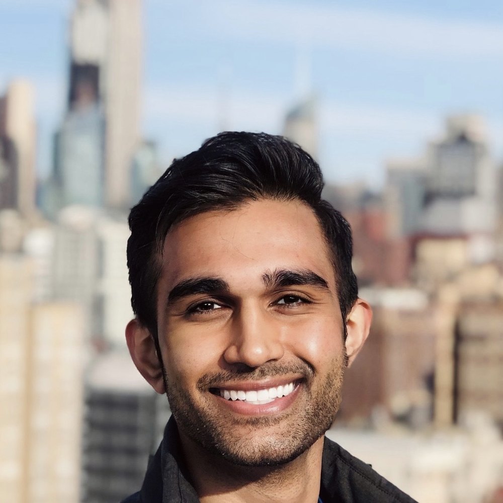Dr. Amit Patel, psychiatrist, smiling in front of the Manhattan skyline